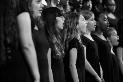 Profile view of a row of singers mid-phrase