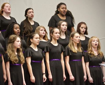 Singers mid-phrase in concert black with purple sashes