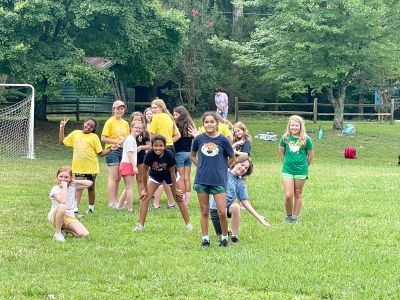 Campers playing and posing together on a grassy field