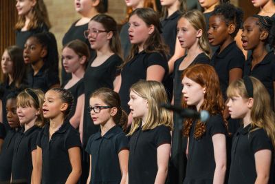 Young singers mid-phrase in close rows