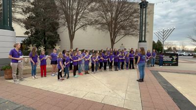 Singers caroling outdoors at a community menorah lighting