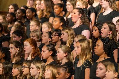 Close view of the massed choir singing in concert black