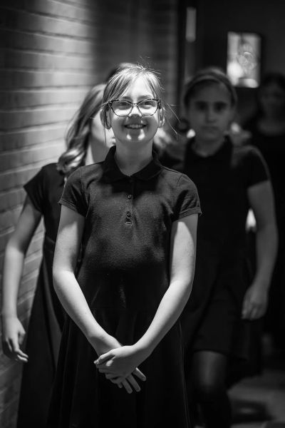 A young singer smiling as the choir lines up backstage