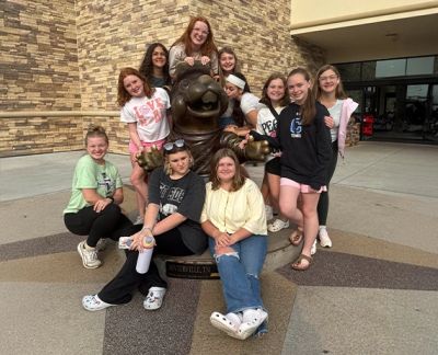 Singers posed around a bronze bear statue in Sevierville, Tennessee