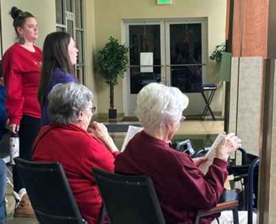 Singers performing for residents at a senior living community