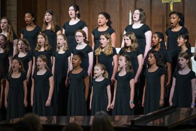 The younger choirs singing on risers beside a grand piano