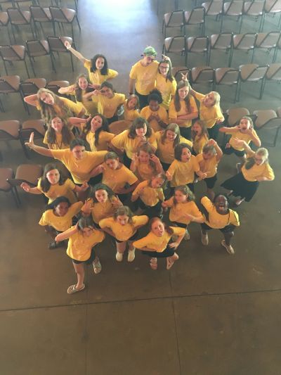 Overhead photo of campers in matching yellow t-shirts posing and laughing