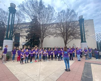 The choir singing outdoors at a community menorah lighting