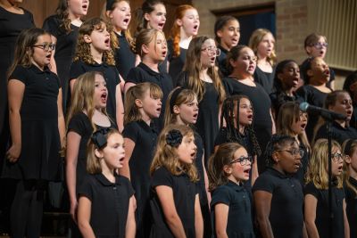 The youngest choir performing in rows at the microphone