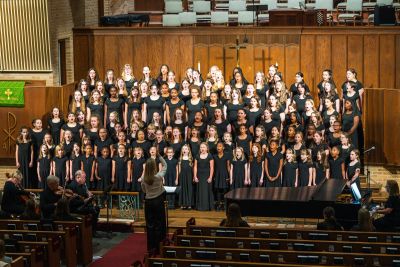 The choir performing with a small string ensemble in the foreground